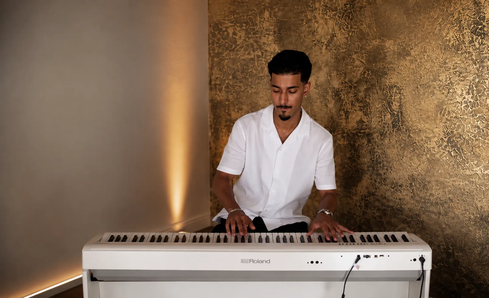 Amaran performing on a white Roland piano